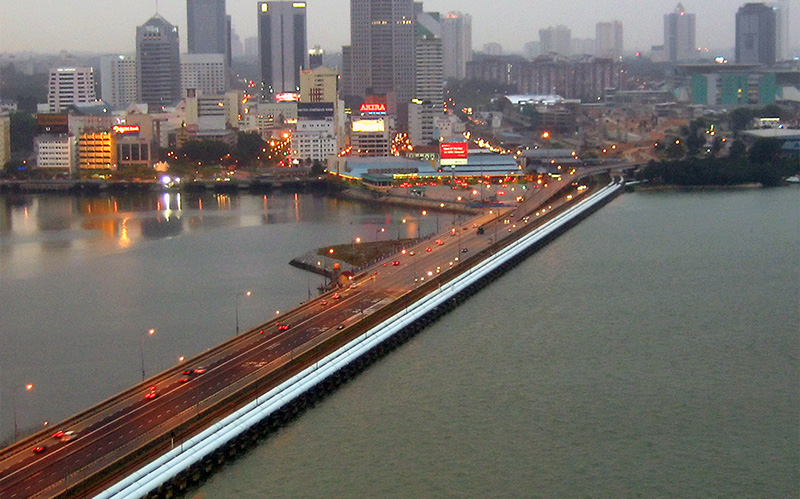 Cross-border commercial moving trucks transporting cargo from Singapore.