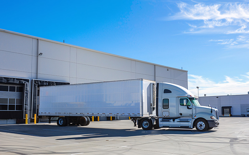 Large semi-truck parked at a logistics loading bay.